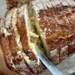 Using a butter knife, spread the garlic butter onto the sourdough slices, being generous with the butter.