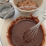 Whisking the sourdough chocolate cake batter with vegetable oil, cocoa, baking soda, baking powder and salt.