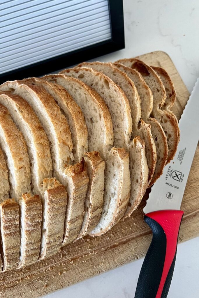 loaf of sourdough bread that has been sliced into even slices using a Mercer Bread Knife.