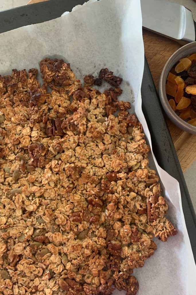 Sourdough granola that has just come out of the oven. It's still in one whole piece and needs to be broken up so it can be used for sourdough snacks.