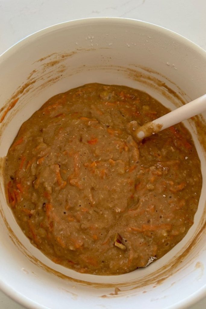 Cream mixing bowl with sourdough carrot cake batter.