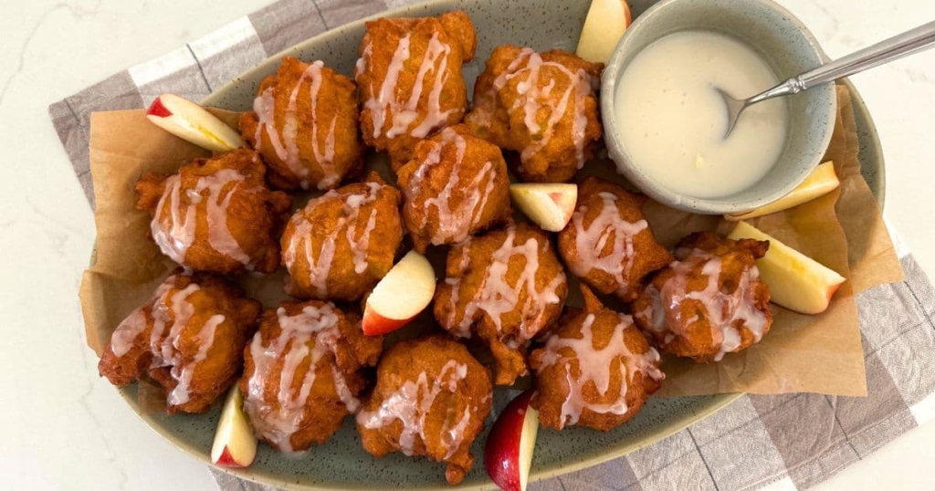 A platter of sourdough apple fritters topped with vanilla glaze.