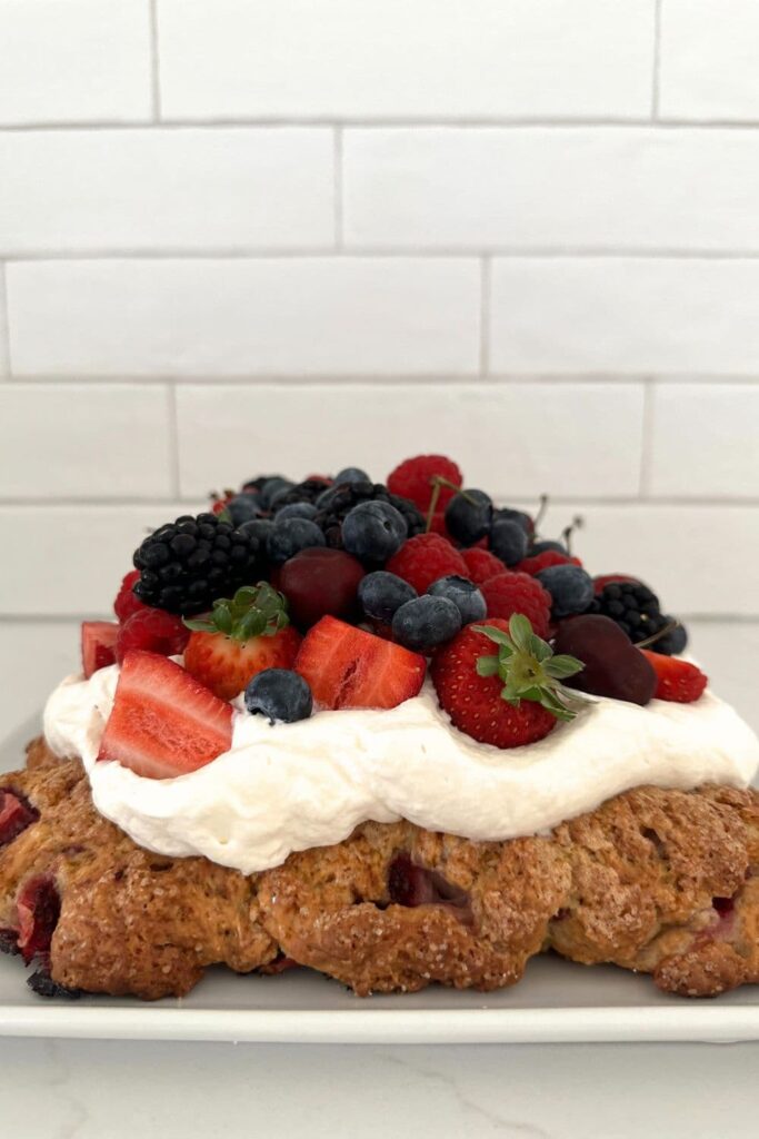 Sourdough berry sheet pan shortcake topped with whipped cream and berries.