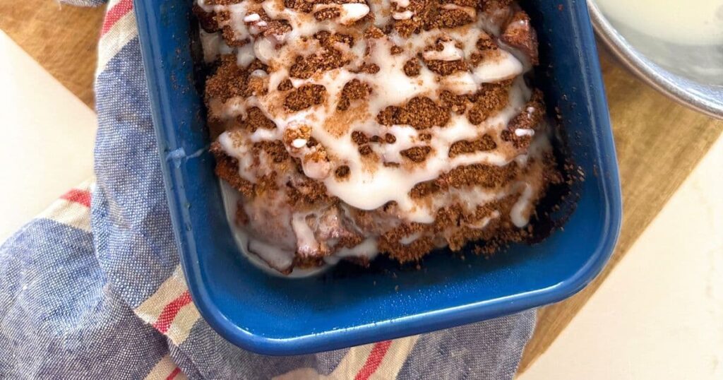 A loaf of sourdough discard apple fritter bread in a blue loaf pan.