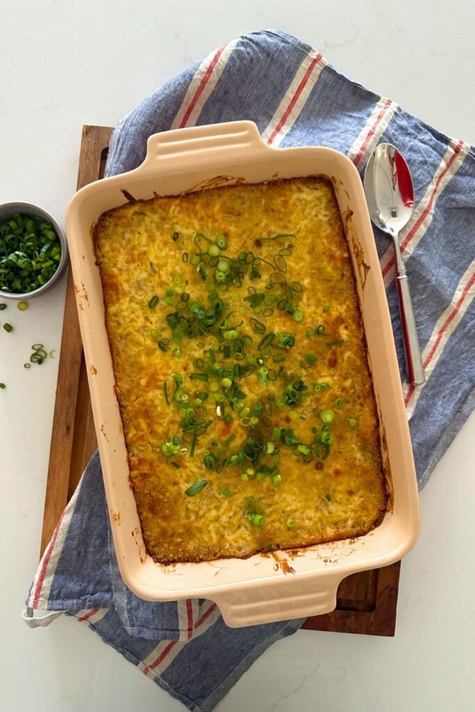 Sourdough hash brown casserole baked in a 9" x 13" baking dish and topped with green onions.