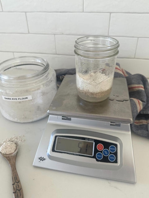 Weighing sourdough ingredients on a digital food scale.
