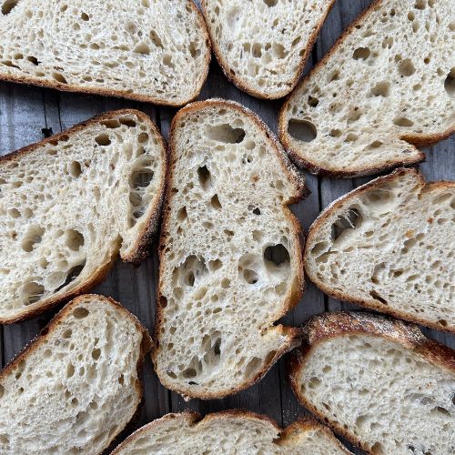 Several slices of sourdough bread arranged in a cluster formation on a gray background.